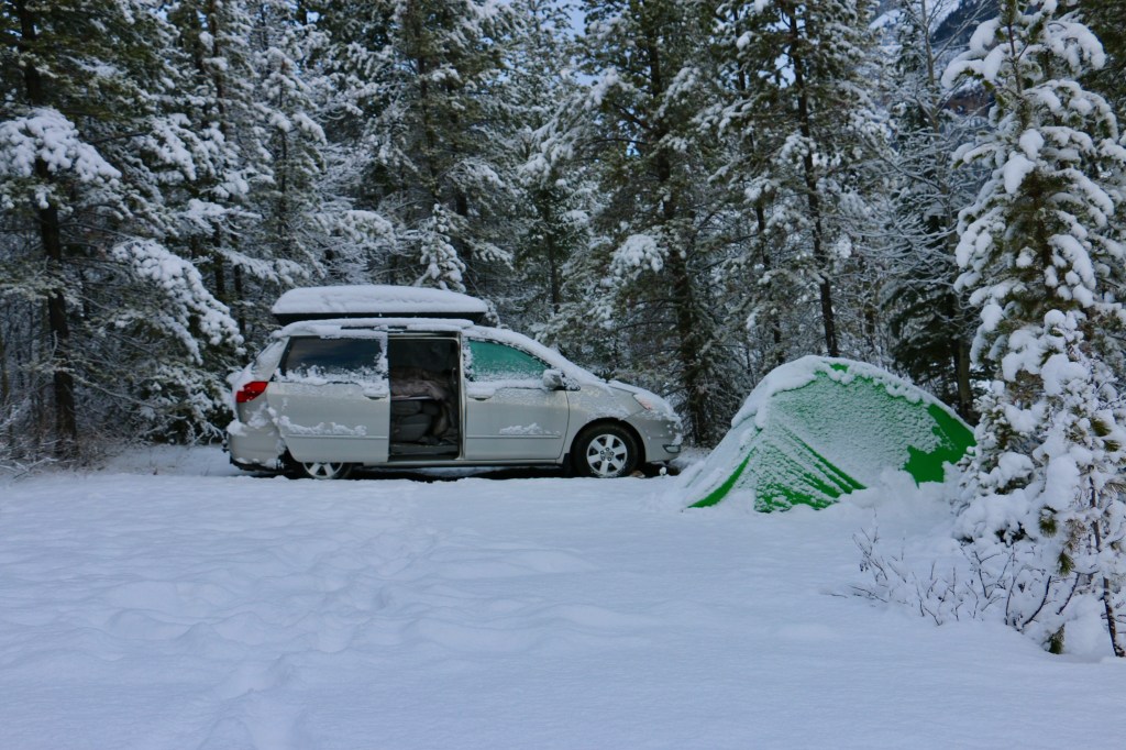 A van and tent in the forest covered in snow